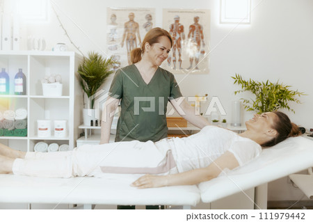 smiling therapist woman in massage cabinet doing checkup 111979442