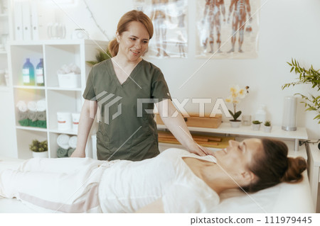 therapist woman in massage cabinet conducting examination 111979445