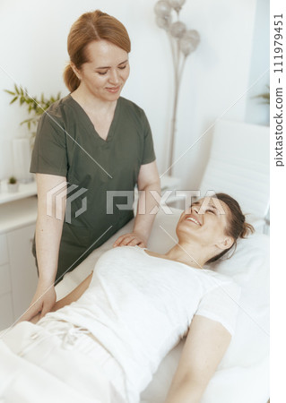 smiling therapist woman in massage cabinet doing checkup 111979451