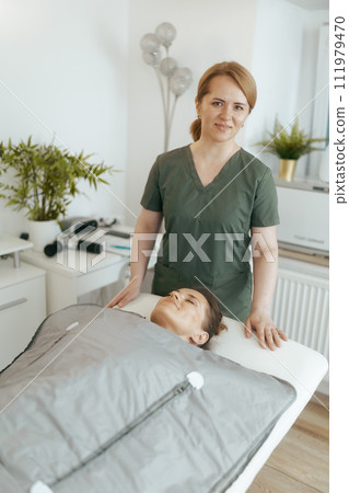happy female medical massage therapist in massage cabinet 111979470