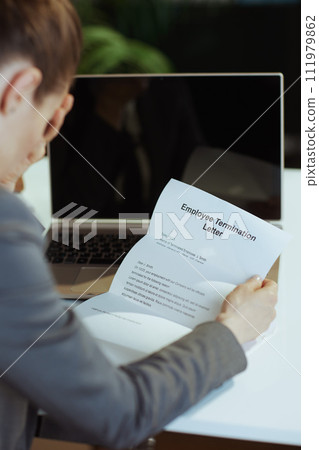 Seen from behind 40 years old woman worker in green office 111979862