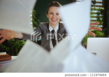 modern woman worker in modern green office throwing documents modern woman worker in modern green office throwing documents 111979864