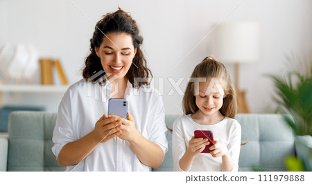 Young mother and daughter using phones Young mother and daughter using phones 111979888
