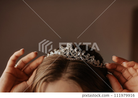 young woman bride straightens accessories on her head and ears 111979916