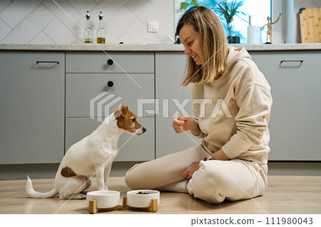 Woman spending time together with her dog at home 111980043