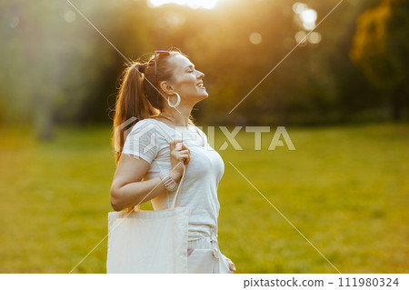 happy modern woman in white shirt in meadow outdoors 111980324