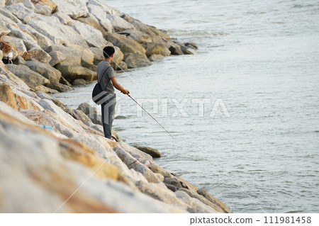 The people fishing at the coast of the sea by the fishing rod with seascape in background 111981458