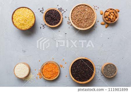 Various superfoods in smal bowl on colored background. Superfood as rice, chia, quinoa, lentils, nuts, sesame seeds, almonds. top view copy space Various superfoods in smal bowl on colored background. Superfood as rice, chia, quinoa, lentils, nuts, sesame seeds, almonds. top view copy space 111981899