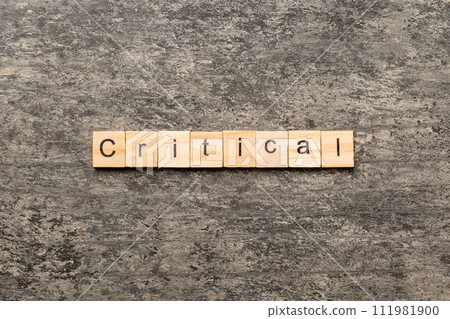 critical word written on wood block. critical text on table, concept critical word written on wood block. critical text on table, concept 111981900