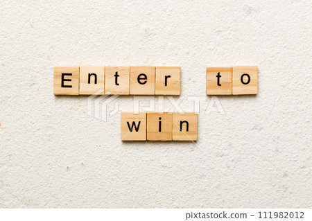 Enter To Win word written on wood block. Enter To Win text on cement table for your desing, concept 111982012