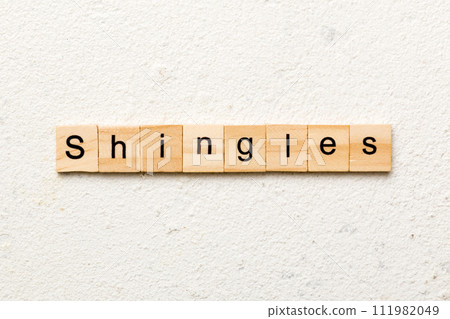 Shingles word written on wood block. Shingles text on cement table for your desing, concept 111982049