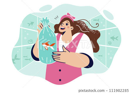 Little girl holds live fish inside polythene bag with water, standing in oceanarium with aquariums 111982285