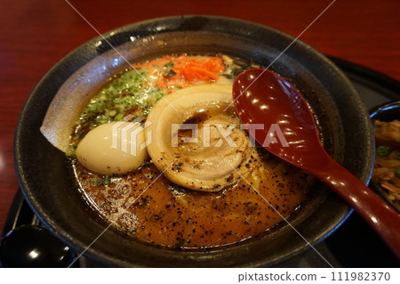 Ramen Japanese noodle dish served in a broth with sliced pork, green onion, boiled egg Ramen Japanese noodle dish served in a broth with sliced pork, green onion, boiled egg 111982370