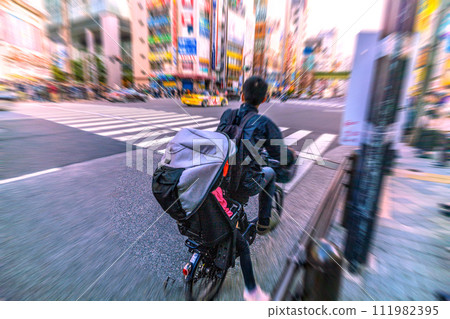 日本東京城市景觀 一輛自行車騎錯了方向...令人驚訝地看到後面有一個孩子...冠狀病毒留下了什麼... = 秋葉原 111982395