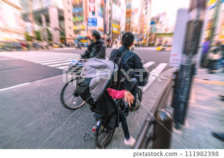 Tokyo cityscape, Japan A bicycle riding in the wrong direction...and it was surprising to see a child behind it...What is left behind by the coronavirus... = Akihabara Tokyo cityscape, Japan A bicycle riding in the wrong direction...and it was surprising to see a child behind it...What is left behind by the coronavirus... = Akihabara 111982398