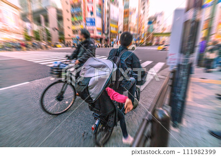 Tokyo cityscape, Japan A bicycle riding in the wrong direction...and it was surprising to see a child behind it...What is left behind by the coronavirus... = Akihabara Tokyo cityscape, Japan A bicycle riding in the wrong direction...and it was surprising to see a child behind it...What is left behind by the coronavirus... = Akihabara 111982399
