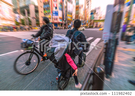 Tokyo cityscape, Japan A bicycle riding in the wrong direction...and it was surprising to see a child behind it...What is left behind by the coronavirus... = Akihabara 111982402