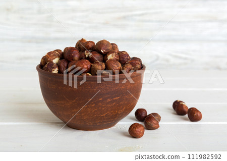 Wooden bowl full of hazelnuts on table background. Healthy eating concept. Super foods 111982592