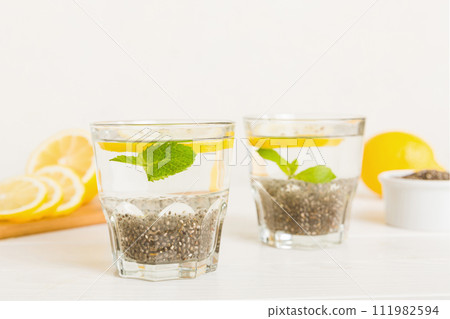 Healthy breakfast or morning with chia seeds lemon and mint on table background, vegetarian food, diet and health concept. Chia pudding with lemon and mint 111982594