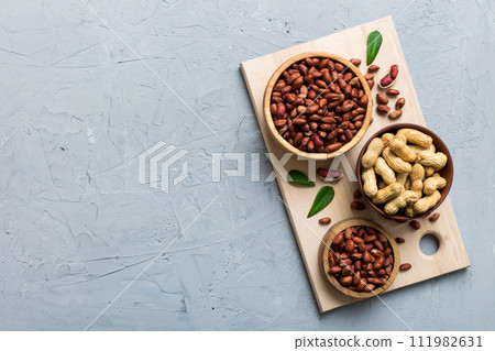 Fresh healthy peanuts in bowl on colored table background. Top view Healthy eating bertholletia concept. Super foods Fresh healthy peanuts in bowl on colored table background. Top view Healthy eating bertholletia concept. Super foods 111982631