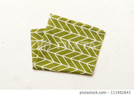 top view with green kitchen napkin isolated on table background. Folded cloth for mockup with copy space, Flat lay. Minimal style top view with green kitchen napkin isolated on table background. Folded cloth for mockup with copy space, Flat lay. Minimal style 111982641