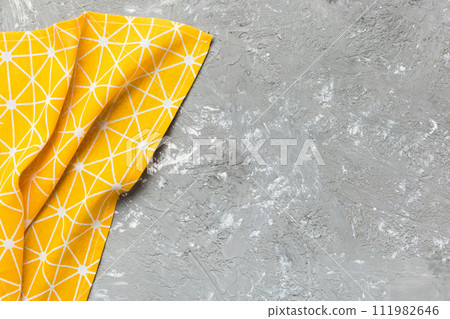 top view with yellow empty kitchen napkin isolated on table background. Folded cloth for mockup with copy space, Flat lay. Minimal style top view with yellow empty kitchen napkin isolated on table background. Folded cloth for mockup with copy space, Flat lay. Minimal style 111982646