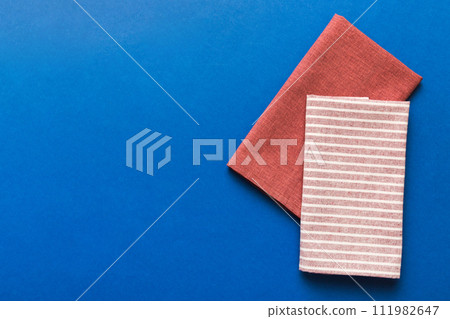 top view with red empty kitchen napkin isolated on table background. Folded cloth for mockup with copy space, Flat lay. Minimal style top view with red empty kitchen napkin isolated on table background. Folded cloth for mockup with copy space, Flat lay. Minimal style 111982647