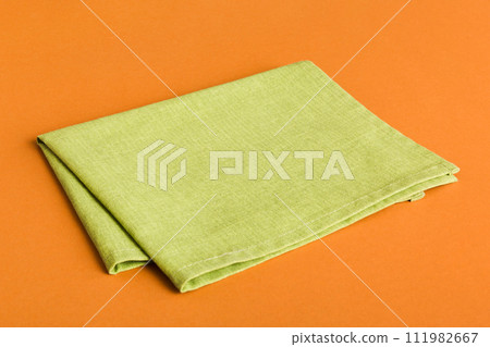 top view with green kitchen napkin isolated on table background. Folded cloth for mockup with copy space, Flat lay. Minimal style top view with green kitchen napkin isolated on table background. Folded cloth for mockup with copy space, Flat lay. Minimal style 111982667