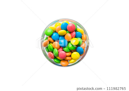 Multicolored candies in a bowl on a colored background. birthday and holiday concept. Top view with copy space Multicolored candies in a bowl on a colored background. birthday and holiday concept. Top view with copy space 111982765