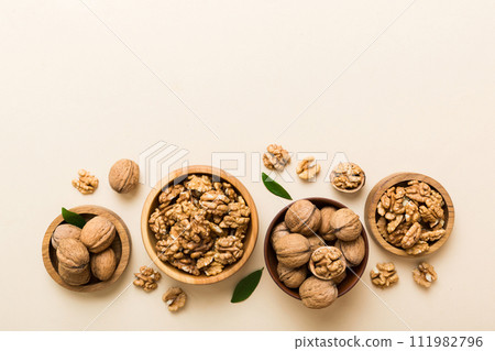 Walnut kernel halves, in a wooden bowl. Close-up, from above on colored background. Healthy eating Walnut concept. Super foods with copy space 111982796