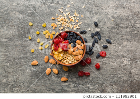 Cooking a wholesome breakfast. Granola with Various dried fruits and nuts in a bowl. The concept of a healthy dessert. Flat lay, top view with copy space 111982901