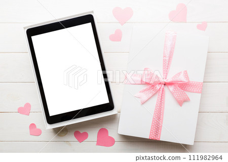 Gift box of open tablet for the holidays with a bow top view Gift box of open tablet for the holidays with a bow top view 111982964