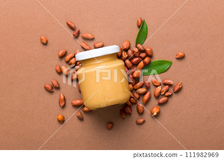 Bowl of peanut butter and peanuts on table background. top view with copy space. Creamy peanut pasta in small bowl 111982969