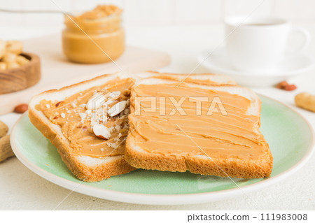 Peanut butter sandwiches or toasts on light table background.Breakfast. Vegetarian food. American cuisine top view vith copy space 111983008