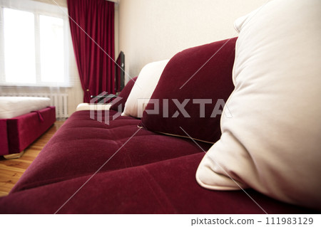 Part of a red sofa with white pillows in the living room. Part of a red sofa with white pillows in the living room. 111983129