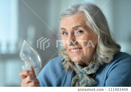 Close-up portrait of an elder woman making inhalation Close-up portrait of an elder woman making inhalation 111983409