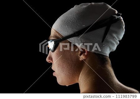 Close up. rear view portrait of young athletic woman with waterdrops on face after swimming race against black studio background. 111983799