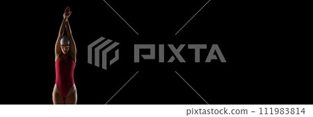 Young, skilled female swimmer in swimwear, goggles and cap against black studio background with negative space to insert text. Young, skilled female swimmer in swimwear, goggles and cap against black studio background with negative space to insert text. 111983814