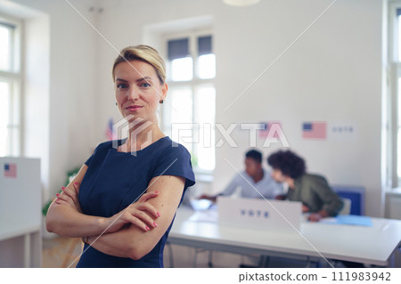 Portrait of female voter filling election ballot paper. US citizen voting in polling place on election day, usa elections. 111983942