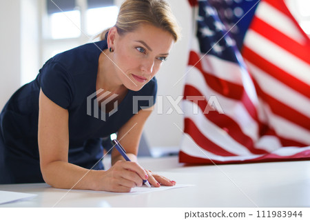 Female voter filling election ballot paper. US citizen voting in polling place on election day, usa elections. Female voter filling election ballot paper. US citizen voting in polling place on election day, usa elections. 111983944