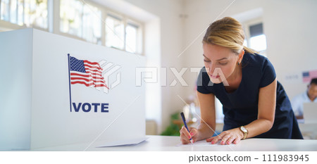 Female voter filling election ballot paper. US citizen voting in polling place on election day, usa elections. Female voter filling election ballot paper. US citizen voting in polling place on election day, usa elections. 111983945