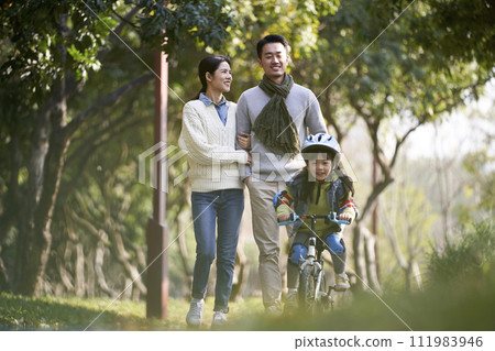 young asian family with one child enjoying outdoor activity in park young asian family with one child enjoying outdoor activity in park 111983946