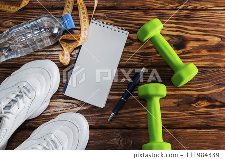 Sports background, headphones, sneakers, dumbbells, health concepts, fitness, weight loss. Sports background, headphones, sneakers, dumbbells, health concepts, fitness, weight loss. 111984339