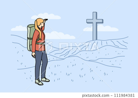 Woman pilgrim stands near large christian cross on hills during hike to sites of ancient cities 111984381