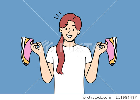 Girl holds running shoes for running or fitness, recommending use high-quality shoes for sports Girl holds running shoes for running or fitness, recommending use high-quality shoes for sports 111984487