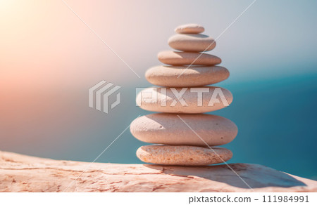 Pyramid stones on the seashore on a sunny day on the blue sea background. Happy holidays. Pebble beach, calm sea, travel destination. Concept of happy vacation on the sea, meditation, spa, calmness. 111984991