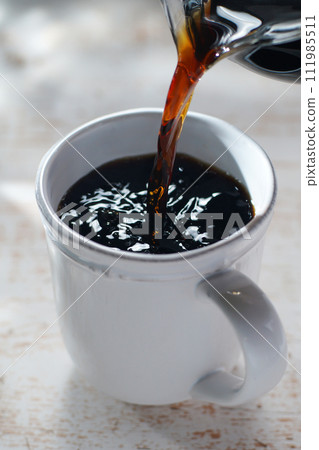 將咖啡倒入杯中 111985511