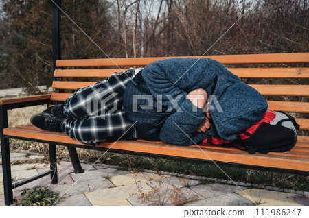 lonely homeless elderly old senior Caucasian man lying sleeping on park bench in autumn lonely homeless elderly old senior Caucasian man lying sleeping on park bench in autumn 111986247