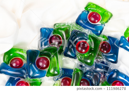 Lots of laundry pods on satin fabric close-up. 111986278