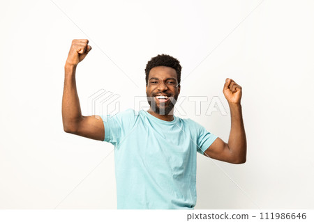 Joyful African American Man Celebrating Success with Arms Raised 111986646